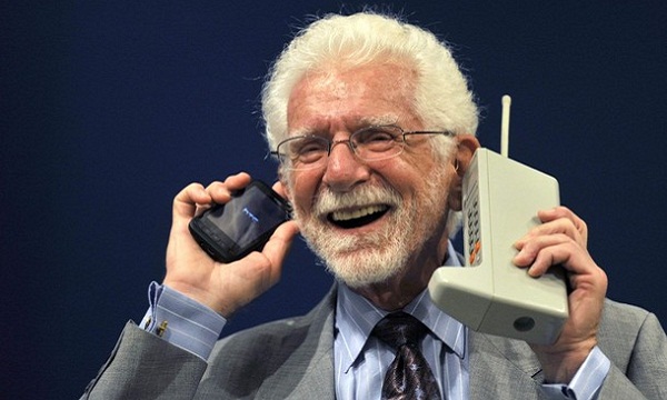 U.S. engineer Martin Cooper holds the Motorola DynaTAC phone, the world's first commercial handheld cellular phone, and his current mobile phone during a news conference in Oviedo