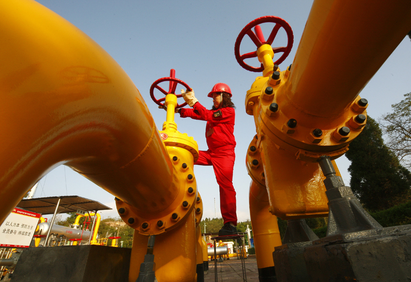 A Chinese worker checks the valve of a g