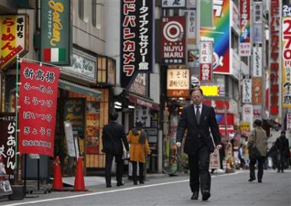 A man walks through a street in Tokyo's Shinjuku district