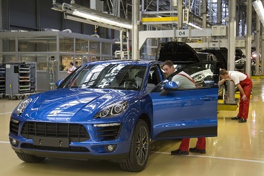 Workers inspect finished Porsche Macan at the new plant in the eastern German city of Leipzig
