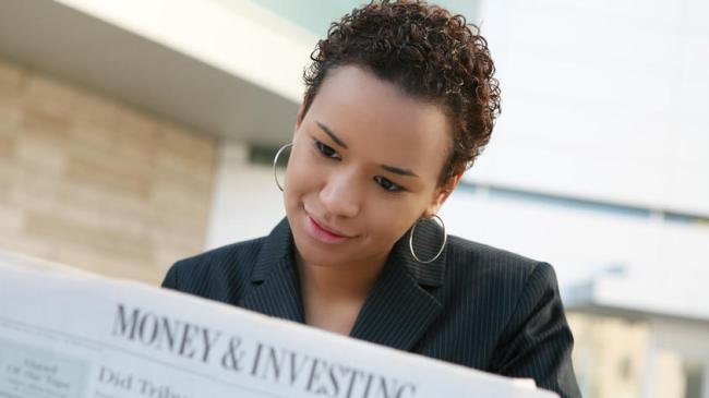 A pretty african american business woman reading the newspaper