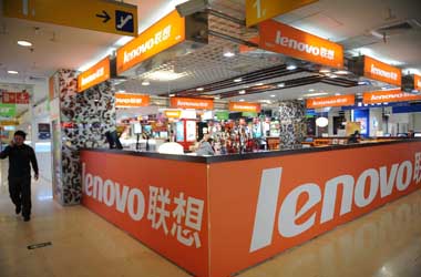A man walks past a Lenovo shop in a comp