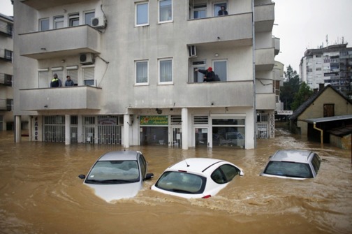 People stand in their apartments as they wait to be evacuated in flooded town of Obrenovac