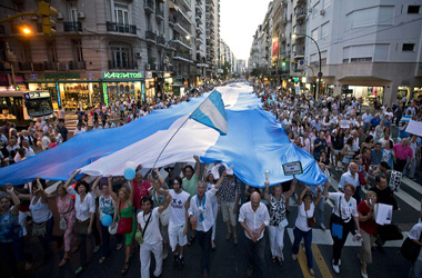 Protesters carry a large Argentine flag during an anti-government dem