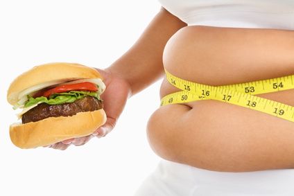 Fat stomach surrounded with measuring tape and burger