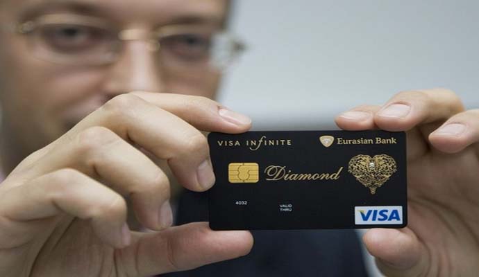 Executive Director of Eurasian Bank shows a new VISA card encrusted with diamond and laced with an elaborate gold pattern in Almaty