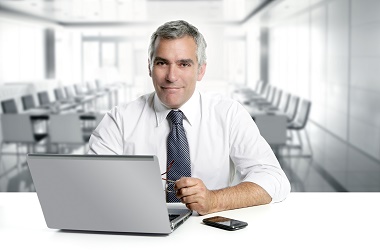 young_business_man_on_a_desk_isolated_on_white_1415366087