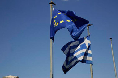 The Greek, right, and the European flags wave under the ancient Acropolis hill in Athens, Sunday, July 5, 2015. Greeks lined up at polling stations and ATMs alike Sunday as the country voted on its financial future, choosing in a referendum whether to accept creditors' demands for more austerity in return for rescue loans or defiantly reject the deal.  (AP Photo/Petros Giannakouris)