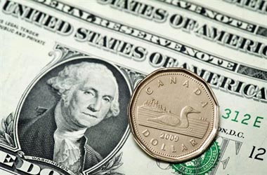 A Canadian dollar is seen next to a series of US dollars Wednesday, January 26, 2011  in Montreal. THE CANADIAN PRESS/Paul Chiasson