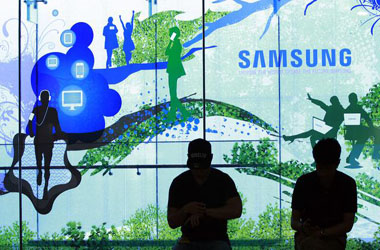 People stand in front of a Samsung Electronics Co's showroom in Seoul, South Korea, Thursday, July 31, 2014. Samsung Electronics Co. reported a bigger-than-expected fall in second quarter profit on Thursday and said it was uncertain if earnings from its handset business would improve in the current quarter.(AP Photo/Ahn Young-joon)