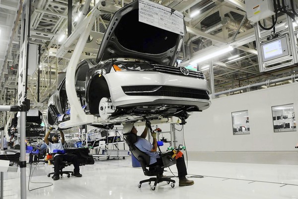 [Workers inspect the undercarriage of a new Passat inside the new Volkswagen plant in Chattanooga, Tenn. on Tuesday, May 24, 2011. Volkswagen is jumping into the U.S. auto market with a new Passat that is bigger, cheaper and built domestically in hopes of breaking into the competitive midsize sedan market. (AP Photo/Billy Weeks)] *** [] ** Usable by LA and DC Only **