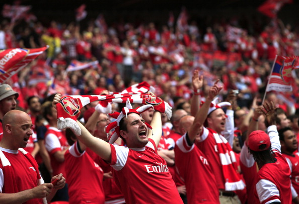 Arsenal fans cheer during the English FA Cup final match between Arsenal and Hull City at Wembly Stadium in London on May 17, 2014. AFP PHOTO/ADRIAN DENNIS  NOT FOR MARKETING OR ADVERTISING USE / RESTRICTED TO EDITORIAL USE        (Photo credit should read ADRIAN DENNIS/AFP/Getty Images)