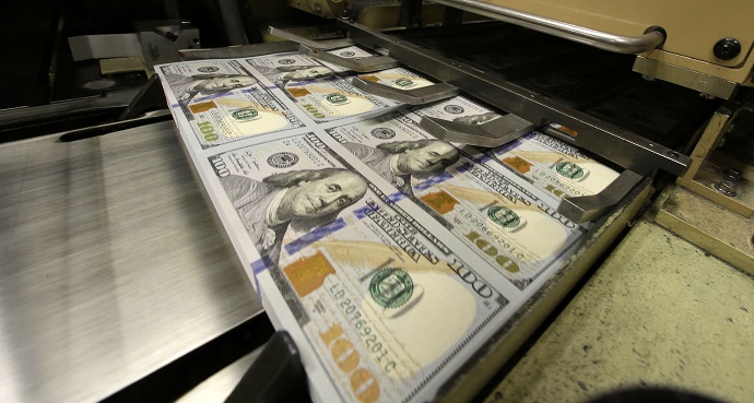Uncut $100 bills run through cutting machine at the Bureau of Engraving and Printing Western Currency Facility in Fort Worth, Texas, Tuesday, Sept. 24, 2013.  The federal printing facility is making the new-look colorful bills that include new security features in advance of the Oct. 8 circulation date.  (AP Photo/LM Otero)