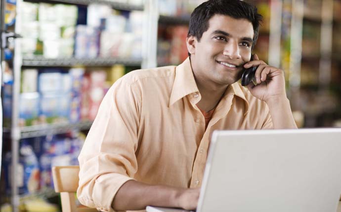 Man on cell phone with laptop