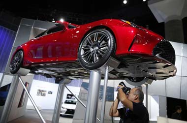 A photographer takes pictures of a Lexus at the 2014 Los Angeles Auto Show in Los Angeles