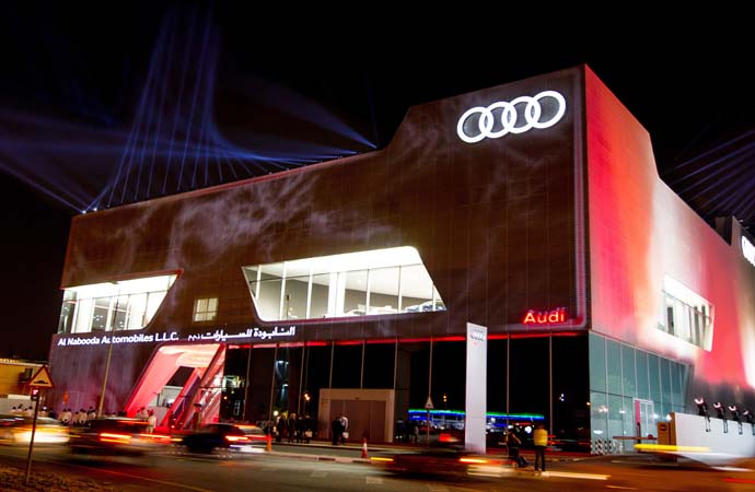 Audi has created a new highlight in the record-setting city: the world’s biggest dealer showroom for the brand opened its doors in Dubai yesterday evening – with singer Jennifer Lopez among the attendees. Visitors to the new Audi terminal will be able to experience up to 57 displayed new cars, more than at any other current dealership for the brand with the four rings. The building erected by the brand’s local dealer “Al Nabooda Automobiles” offers more than 8,700 square meters of display and office space on three storeys. Two elevators transport the Audi models between the levels. The second floor is especially exclusive: it is completely reserved for the Audi exclusive portfolio. Extensive color and material samples and a consultant from quattro GmbH await customers who want to design their very own one-of-a-kind Audi: this kind of service is in especially high demand by Audi drivers in the markets of this region. With the “Powerwall”, a new digital presentation technology from the recently launched “Audi City” store concept in London has also found its way to the Dubai terminal: Floor-to-ceiling screens show the Audi model range including all equipment options, features and technical details in a lifelike 1:1 scale. Visitors to Audi’s flagship dealership in the region will also find many other exclusive service facilities, including a prayer room for customers and employees. Audi terminal is the name of the worldwide brand architecture of the four rings for dealerships. AUDI AG developed its master plan together with the Munich-based architecture agency Allmann Sattler Wappner Architekten. The bold terminal architecture with its folded aluminum facade and curved display areas has now been constructed at nearly 400 locations around the globe. The first Audi terminal went online in 2008 in Sydney.  Opening Audi terminal Dubai
