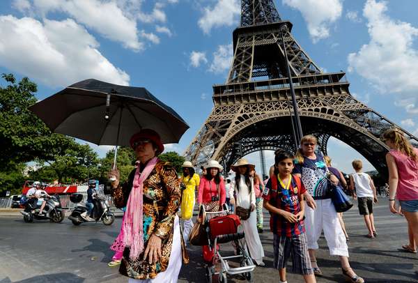 Tourists gather near Paris' Eiffel Tower on a sunny summer day in 2013. (AFP/Getty photo by Miguel Medina)