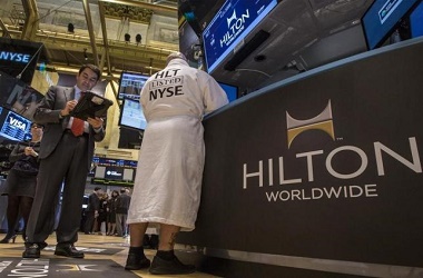 Specialist Trader John O'Hara (R) wears a Hilton branded bathrobe to celebrate Hilton's IPO, while working at his post on the floor of the New York Stock Exchange, December 13, 2013. REUTERS/Brendan McDermid