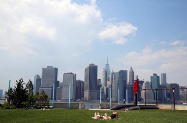 The skyline of lower Manhattan is seen as people lay on the grass in Brooklyn Bridge Park in the Brooklyn borough of New York City, U.S., May 27, 2016. REUTERS/Brendan McDermid