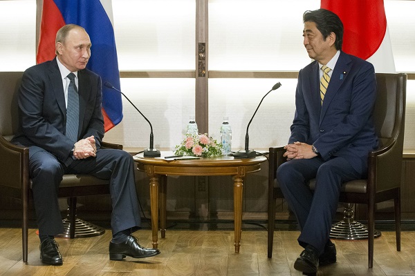 Japanese Prime Minister Shinzo Abe, right, listens to Russian President Vladimir Putin during their meeting at a hot springs resort in Nagato, western Japan, Thursday, Dec. 15, 2016. Despite continued sanctions on Russia, Abe is eager to make progress on a 70-year-old territorial dispute that has kept their countries from signing a peace treaty formally ending World War II. (AP Photo/Alexander Zemlianichenko, pool)
