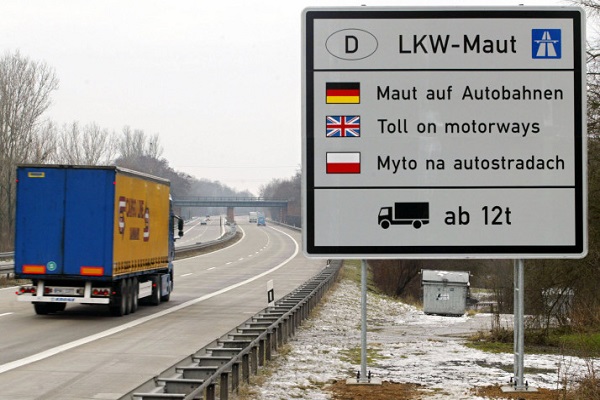 FRANKFURT/ODER, Germany: A truck drives on the motorway past a plate announcing toll has to be paid 28 December 2004 near the German-Polish border near Frankfurt/Oder, before the launch of the motorway toll for trucks from 01 January 2005. From then on, all heavy goods vehicles will be installed with a satellite-driven on-board-unit (or OBU), which will track their progress on the Autobahn. Infrared detection systems will read the license plates of the lorries and trucks and check whether they have been registered with a database. AFP PHOTO DDP/FABIAN MATZERATH GERMANY OUT (Photo credit should read FABIAN MATZERATH/AFP/Getty Images)