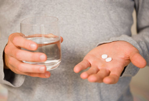 thinkstock_rf_man_holding_glass_of_water_and_pills