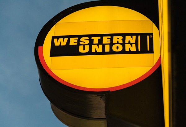 DOWNTOWN, TORONTO, ONTARIO, CANADA - 2015/08/23: The glowing signage of Western Union at its agent location in Toronto. The Western Union Company is an American financial services and communications company providing fast and reliable money transfer services. (Photo by Roberto Machado Noa/LightRocket via Getty Images)