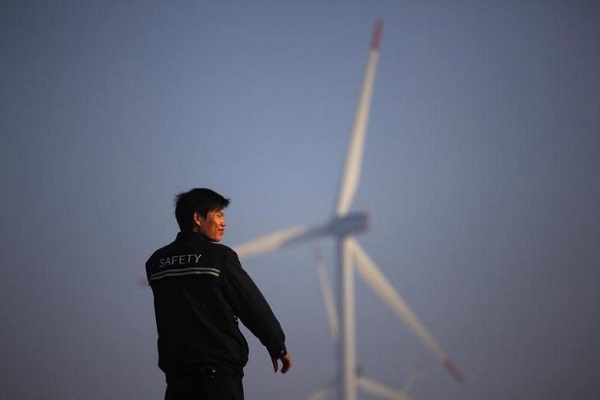 A security guard stands in front of windmills used to generate energy in Shanghai November 28, 2011. REUTERS/Aly Song