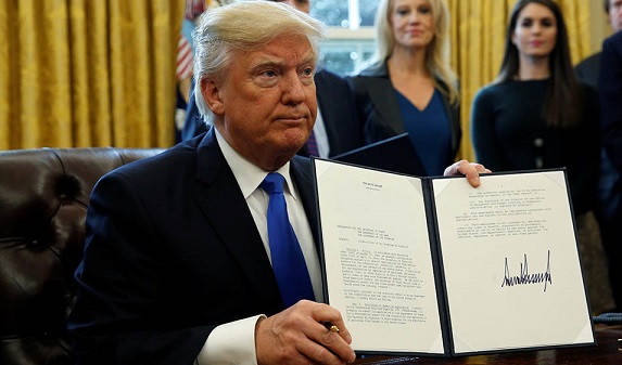 U.S. President Donald Trump holds up a signed executive order to advance construction of the Keystone XL pipeline at the White House in Washington January 24, 2017. REUTERS/Kevin Lamarque TPX IMAGES OF THE DAY - RTSX5N8